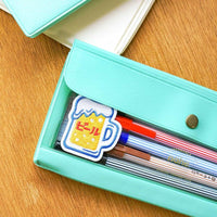 Turquoise pencil case with stationery items on a wooden surface